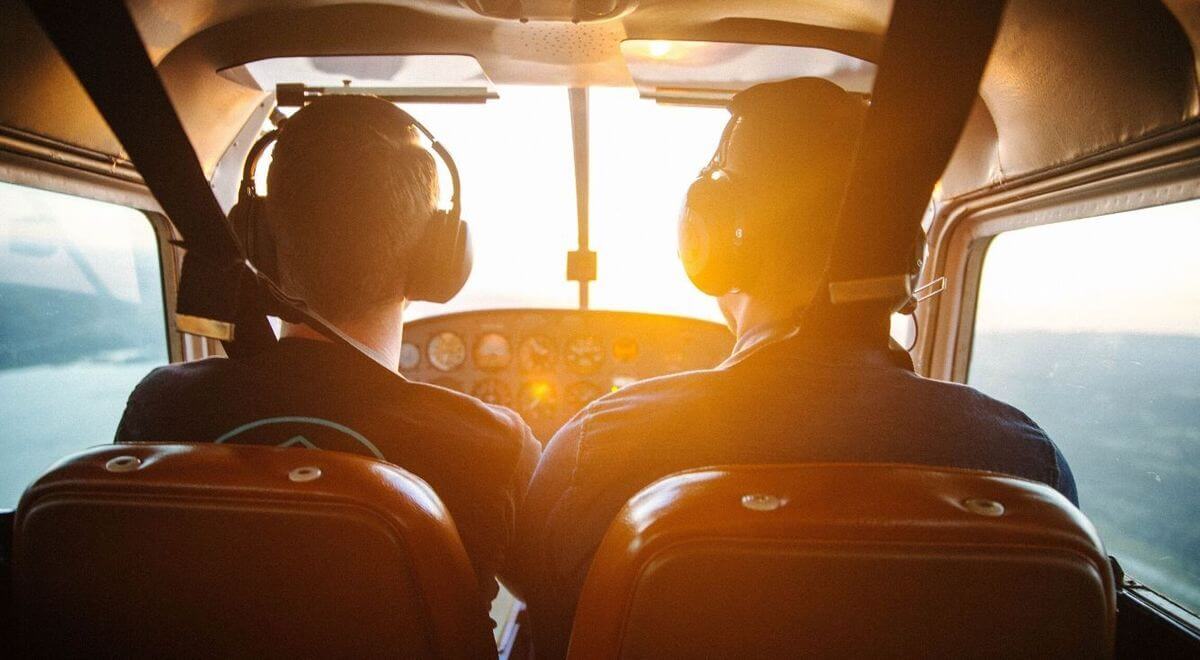 two men piloting plane during daytime