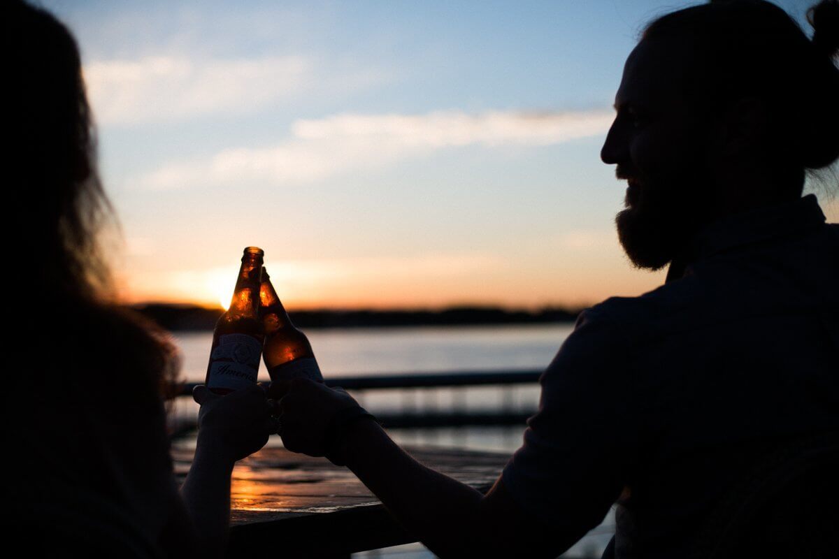 silhouette of man and woman holding beer