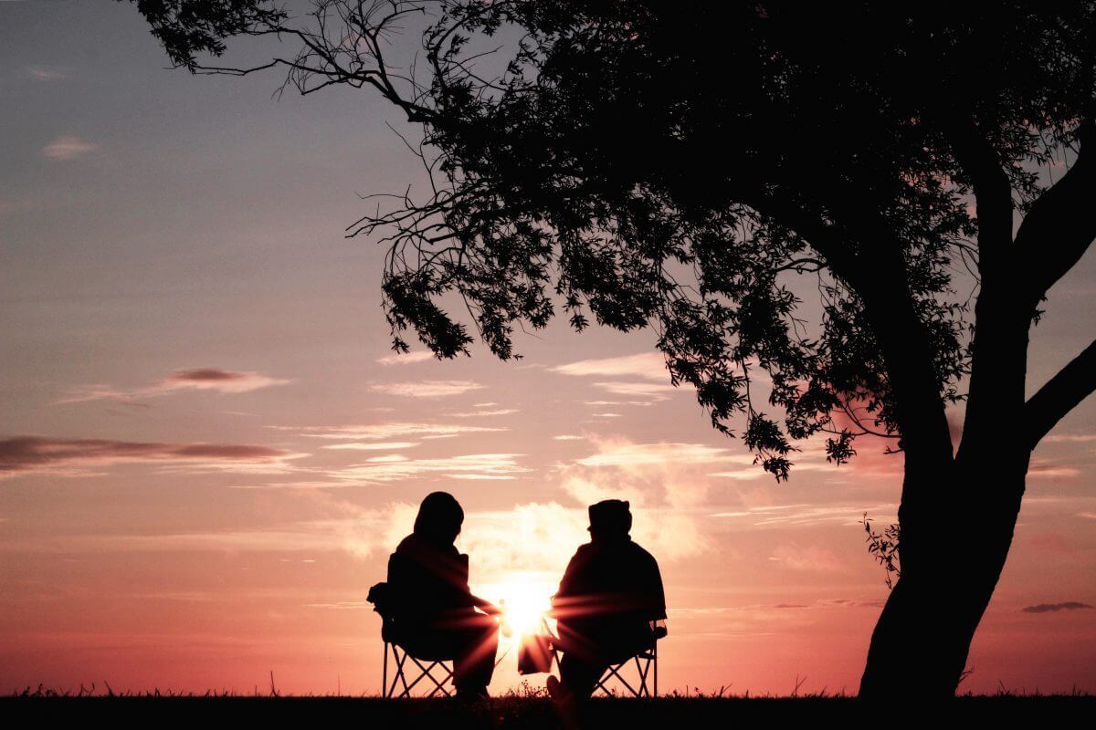 silhouette of two person sitting on chair